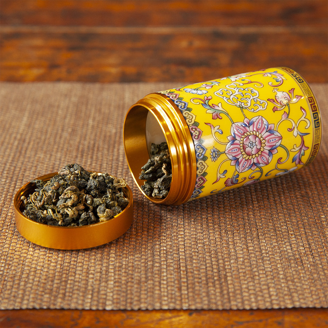 Yellow ceramic travel tea caddy with tea leaves