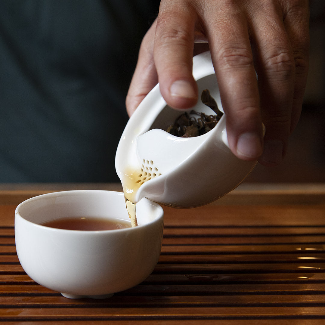 Pouring tea from the single brew teapot into the cup