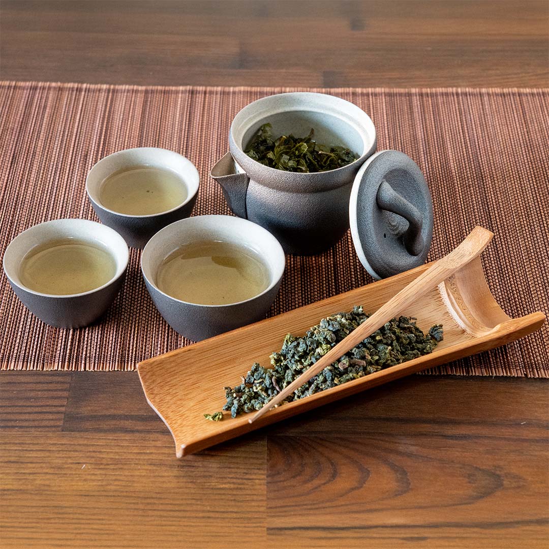 Travel Tea Set Behind Tea Leaves in a Scoop