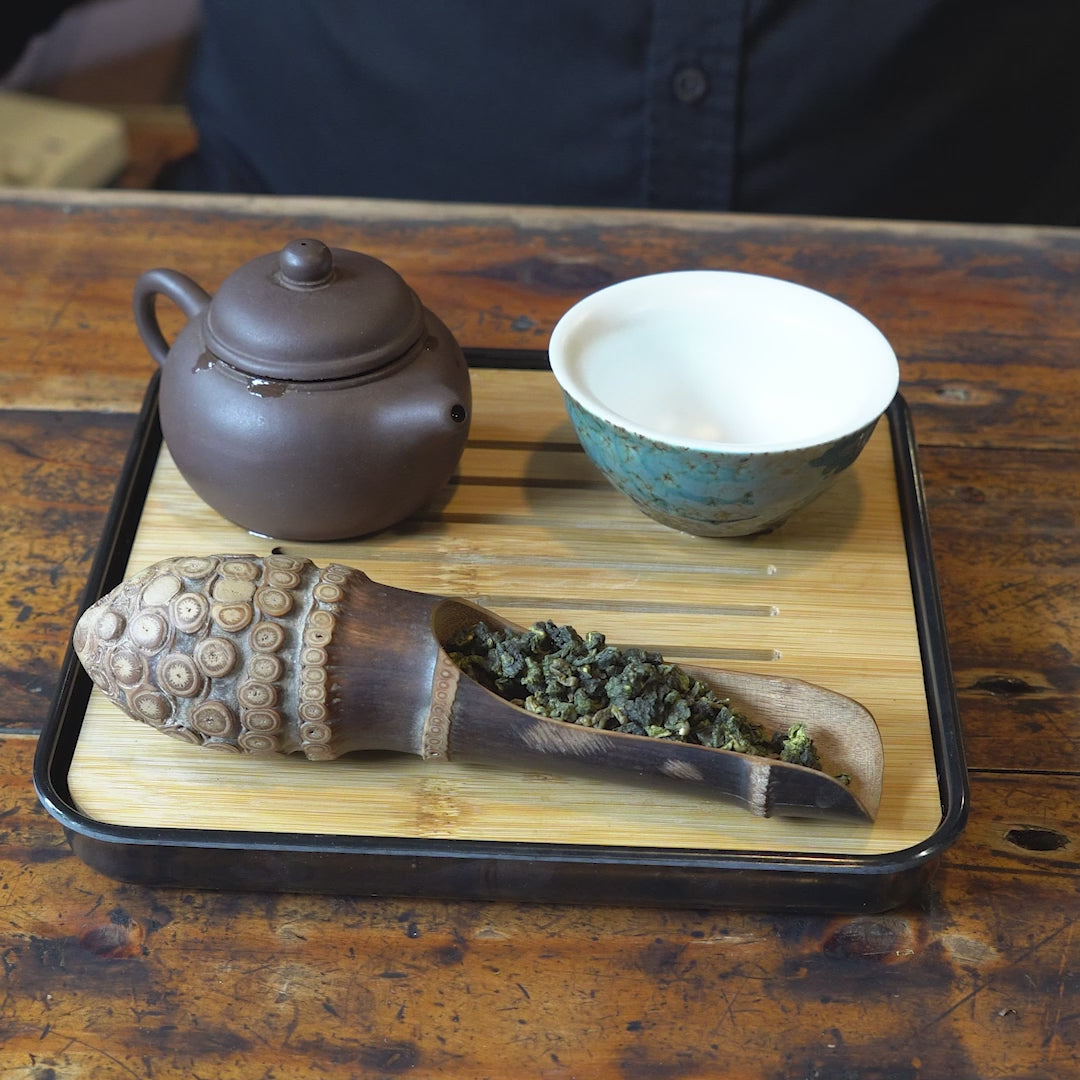 Pouring tea on a portable bamboo tea tray.