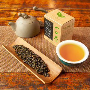 Eco-Cha Teas Eco-Farmed High Mountain Oolong Tea on table with package and teapot