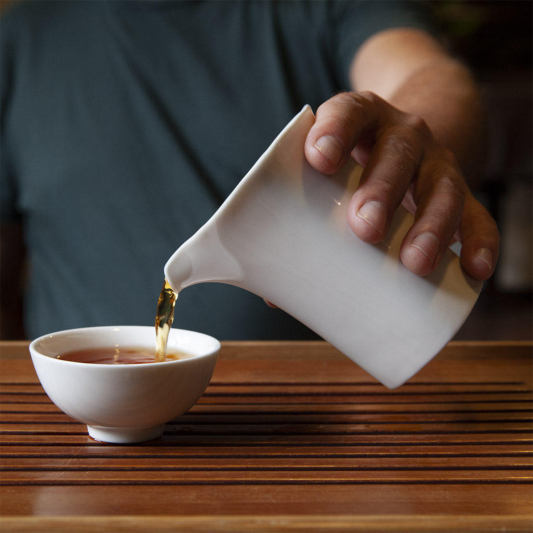 White porcelain tea cup with tea pitcher