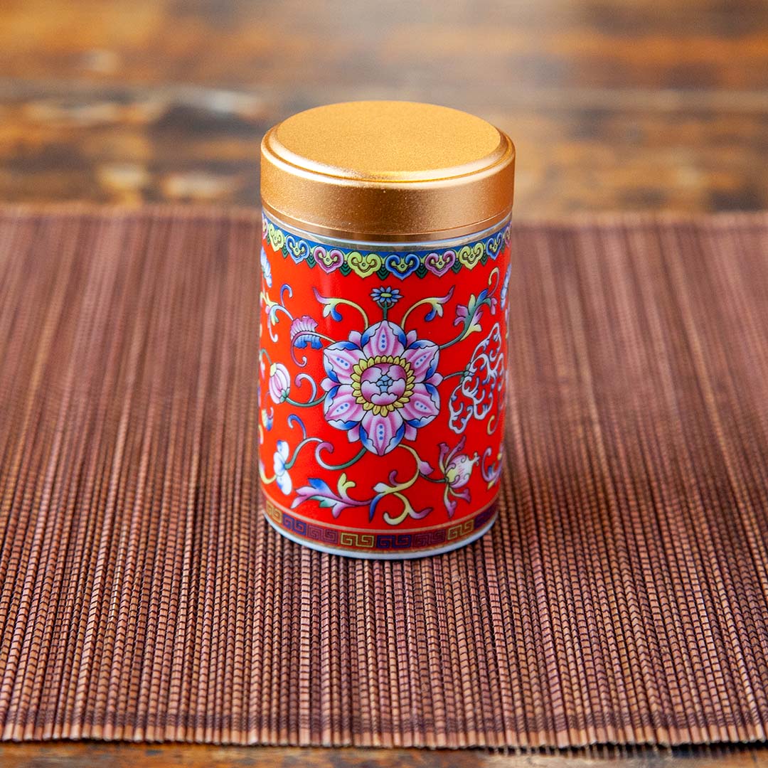 Portable red ceramic travel tea caddy with floral design standing up