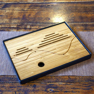 Portable bamboo tea tray on wooden table