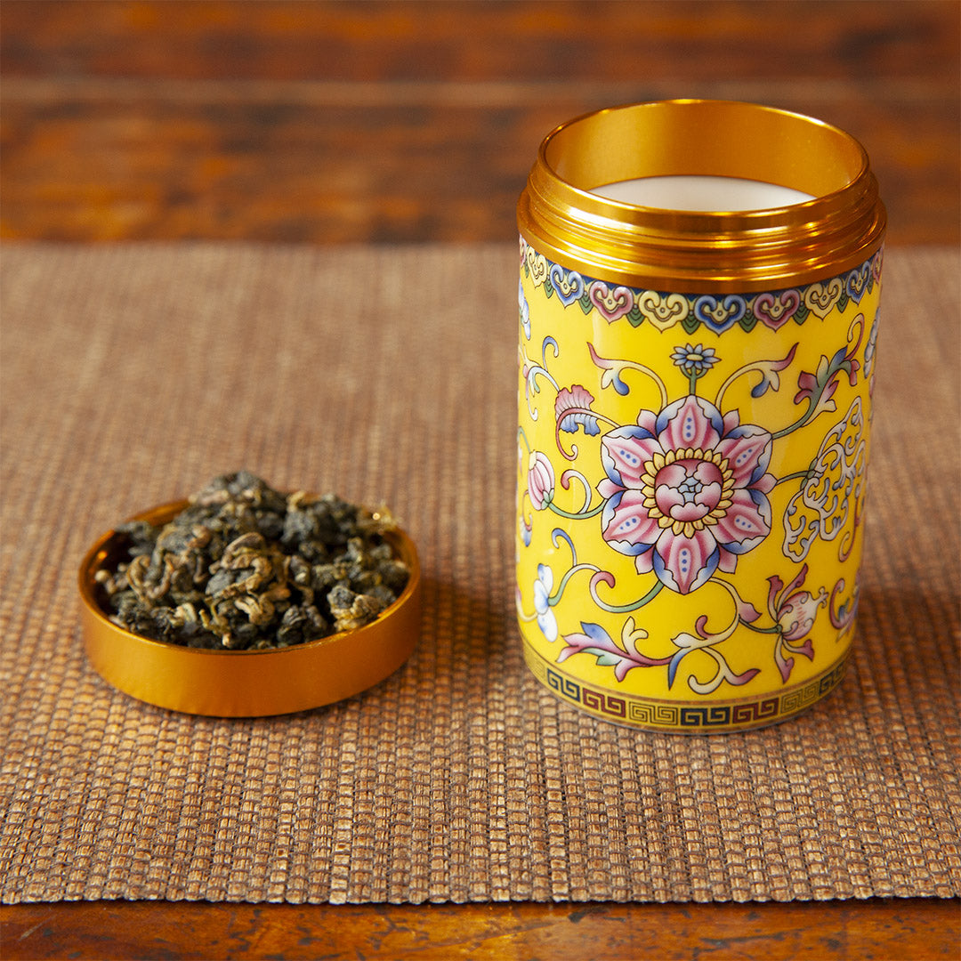 Yellow ceramic tea caddy with tea leaves in cap